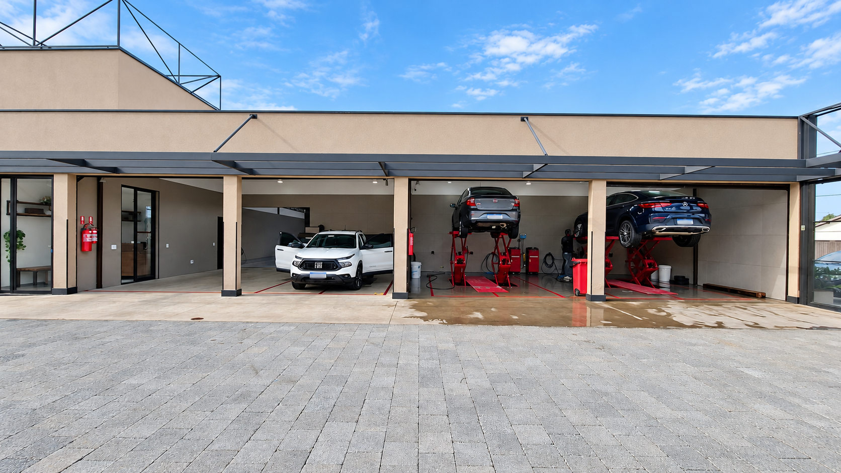 Boxes de atendimento da AR7 Car Wash em Campinas com veículos elevados em plataformas